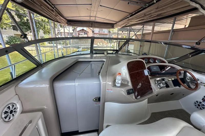  Yacht Photos Pics 2004 Sea Ray 380 Sundancer cockpit with steering wheel, dashboard, and seating under canopy.