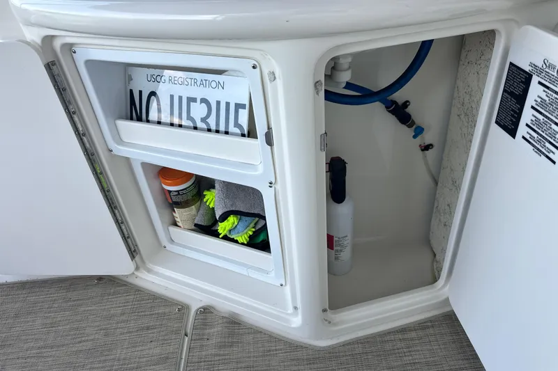  Yacht Photos Pics Open storage compartment on 2004 Sea Ray 380 Sundancer with registration and cleaning supplies.