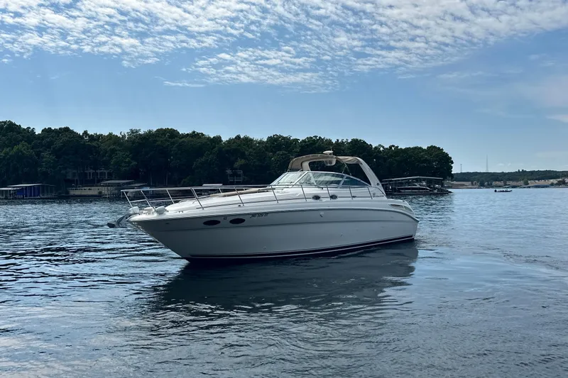 Yacht Photos Pics 2004 Sea Ray 380 Sundancer yacht on a serene lake with wooded shoreline.