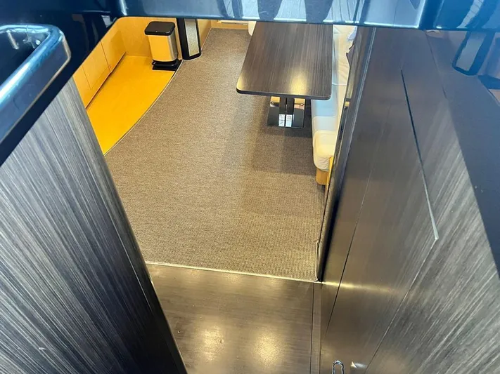  Yacht Photos Pics Interior of 2010 Riva Vertigo 63 yacht, featuring modern wood paneling and a cozy seating area.