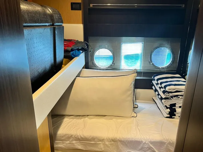  Yacht Photos Pics Cozy cabin interior of 2010 Riva Vertigo 63 yacht with porthole windows and striped linens.