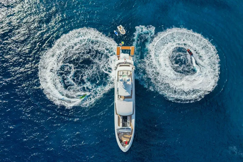 Okko Yacht Photos Pics Aerial view of 2013 Mondomarine 41M yacht with jet skis creating circular patterns in the ocean.