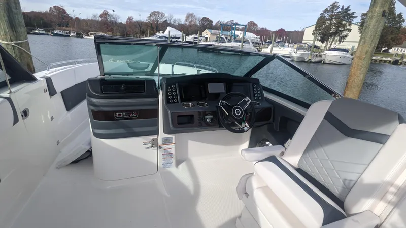  Yacht Photos Pics 2020 Chaparral 280 OSX boat cockpit with modern controls and seating, docked by a marina.