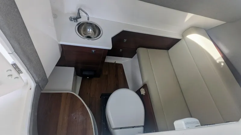  Yacht Photos Pics 2020 Chaparral 280 OSX boat interior with sink, toilet, and seating area.