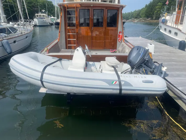 Minkie B Yacht Photos Pics 1997 Lyman-Morse Custom Flybridge with inflatable dinghy docked in a marina.