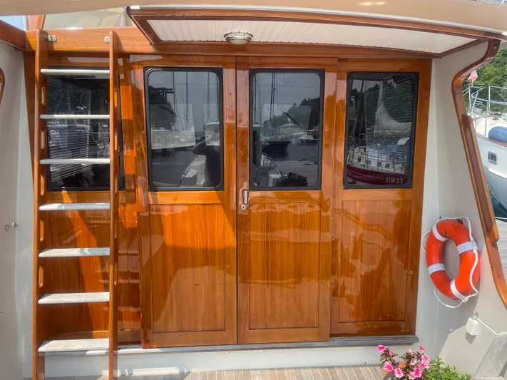Minkie B Yacht Photos Pics 1997 Lyman-Morse Custom Flybridge with polished wood doors and ladder, featuring a life preserver.