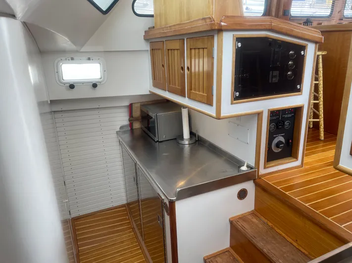 Minkie B Yacht Photos Pics 1997 Lyman-Morse Custom Flybridge interior with wooden cabinetry and stainless steel countertop.