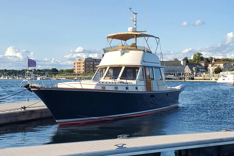 Minkie B Yacht Photos Pics 1997 Lyman-Morse Custom Flybridge yacht docked in a marina under a clear blue sky.