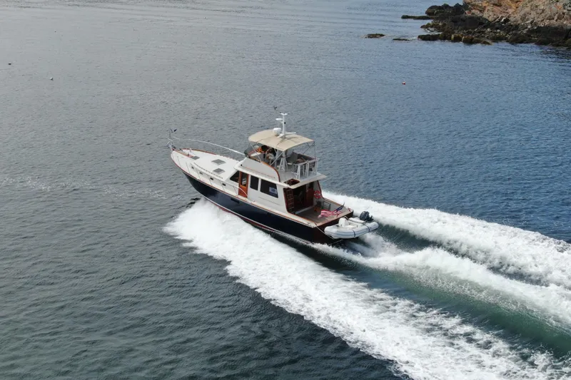 Minkie B Yacht Photos Pics 1997 Lyman-Morse Custom Flybridge yacht cruising on open water.