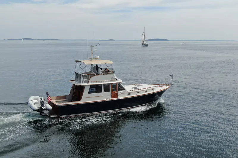 Minkie B Yacht Photos Pics 1997 Lyman-Morse Custom Flybridge yacht cruising on calm ocean waters.