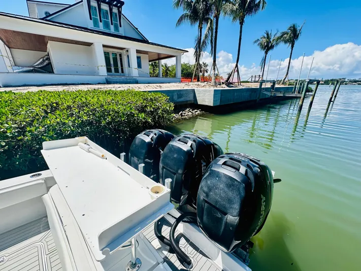  Yacht Photos Pics 2000 Luhrs Tournament 320 Open boat docked near waterfront house with palm trees.