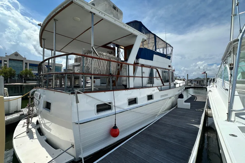 Maren Yacht Photos Pics 1980 Island Gypsy Flush Aft Deck Trawler-Motor Yacht docked at marina under cloudy sky.