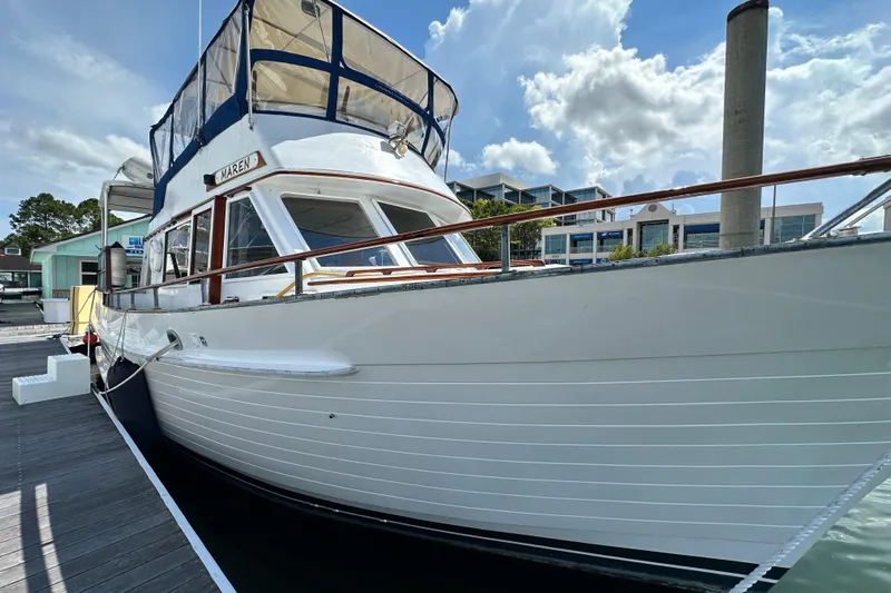 Maren Yacht Photos Pics 1980 Island Gypsy Flush Aft Deck Trawler-Motor Yacht docked under a blue sky.