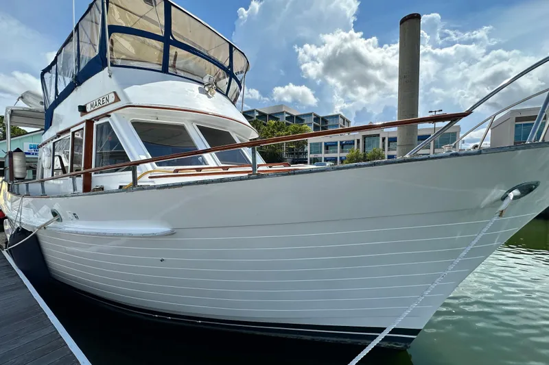 Maren Yacht Photos Pics 1980 Island Gypsy Flush Aft Deck Trawler-Motor Yacht docked under a cloudy sky.
