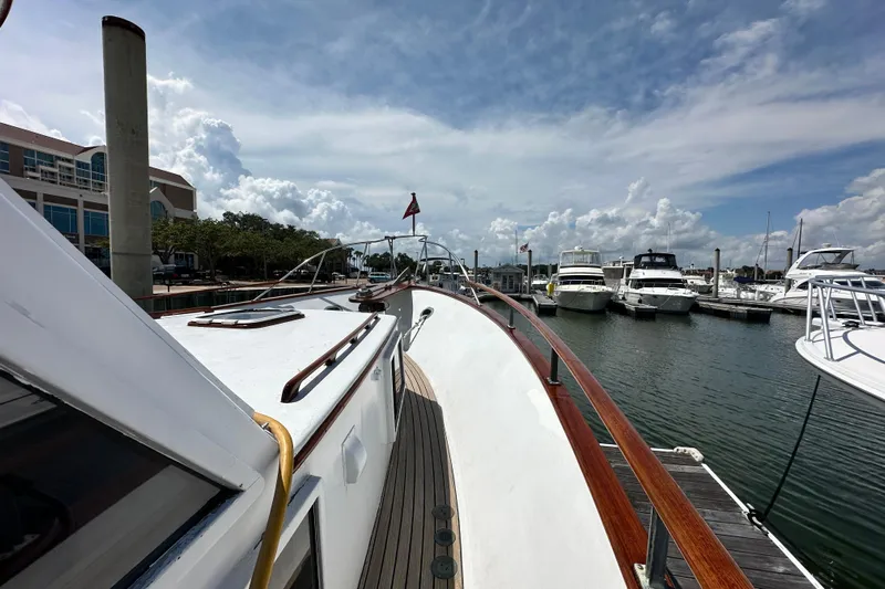 Maren Yacht Photos Pics 1980 Island Gypsy Flush Aft Deck Trawler-Motor Yacht docked at marina under cloudy sky.