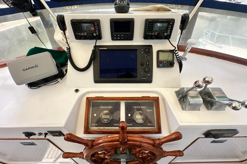 Maren Yacht Photos Pics 1980 Island Gypsy yacht helm with navigation equipment, wooden wheel, and control levers.