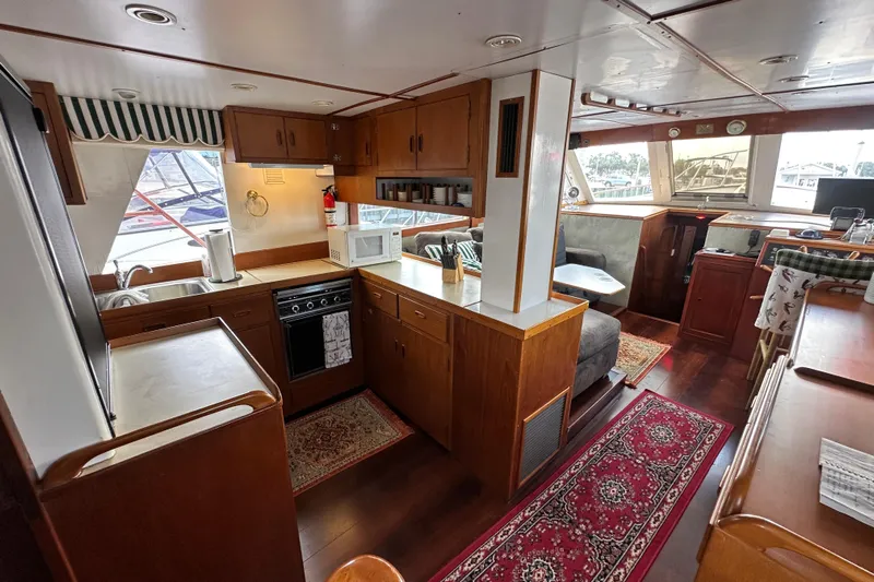 Maren Yacht Photos Pics 1980 Island Gypsy Flush Aft Deck Trawler-Motor Yacht interior with kitchen and seating area.