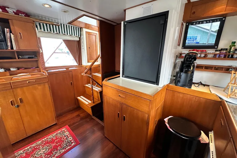 Maren Yacht Photos Pics 1980 Island Gypsy yacht interior with wooden cabinetry, stairs, and kitchen area.