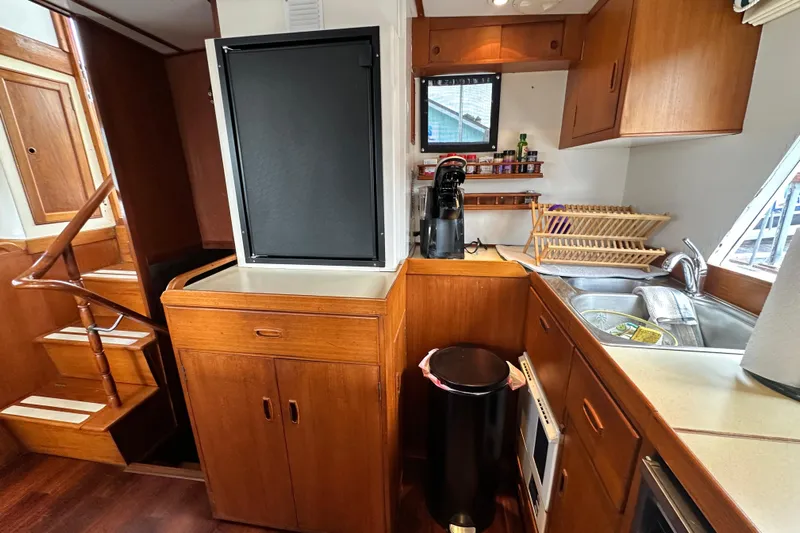 Maren Yacht Photos Pics 1980 Island Gypsy yacht kitchen with wooden cabinetry, stairs, and modern appliances.