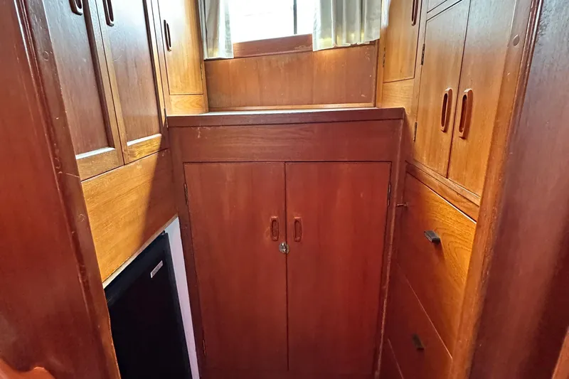 Maren Yacht Photos Pics 1980 Island Gypsy yacht interior with wooden cabinets and drawers, featuring natural light.