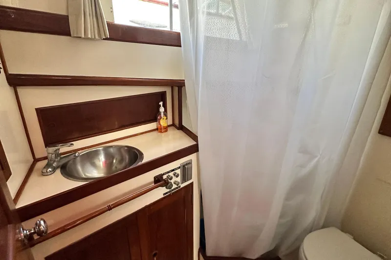 Maren Yacht Photos Pics 1980 Island Gypsy yacht bathroom with sink, faucet, and shower curtain.