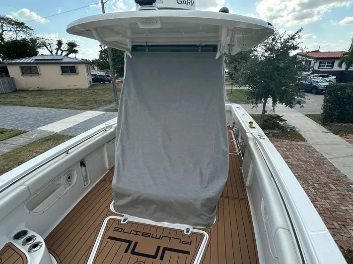  Yacht Photos Pics 2013 Boston Whaler 320 Outrage boat with covered console, docked in a residential area.