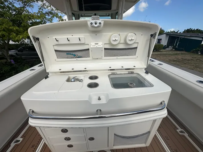  Yacht Photos Pics 2013 Boston Whaler 320 Outrage boat with open storage compartment and fishing amenities.