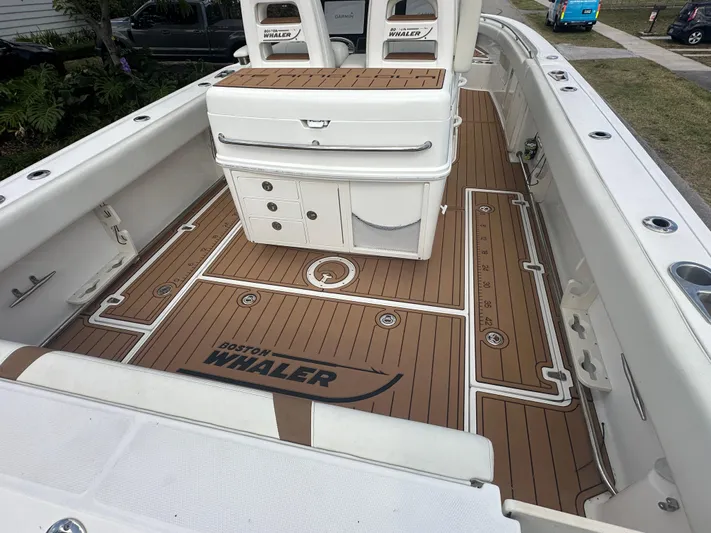  Yacht Photos Pics 2013 Boston Whaler 320 Outrage boat interior with teak-style flooring and storage compartments.