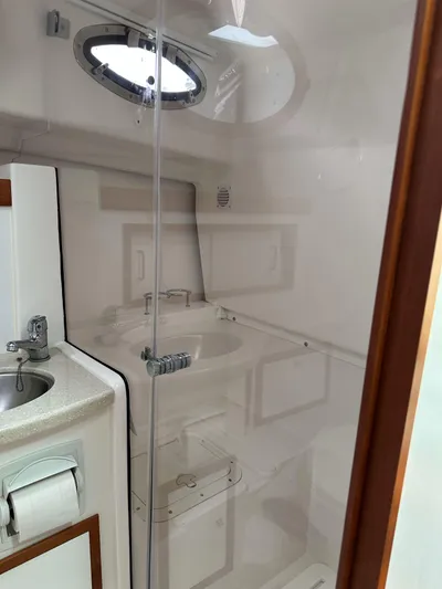 Waters Edge Yacht Photos Pics 2018 Back Cove Downeast 37 yacht bathroom with modern fixtures and porthole window.
