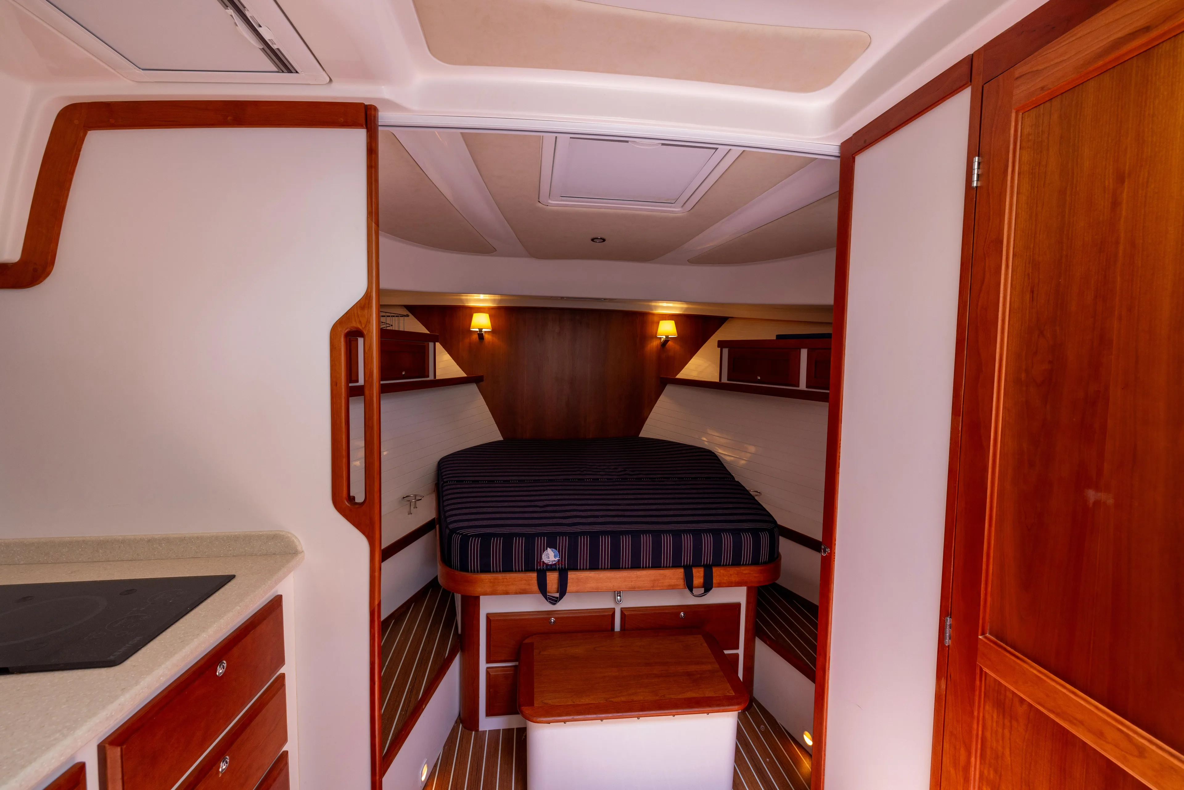 Waters Edge Yacht Photos Pics 2018 Back Cove Downeast 37 cabin interior with bed, wooden accents, and ambient lighting.