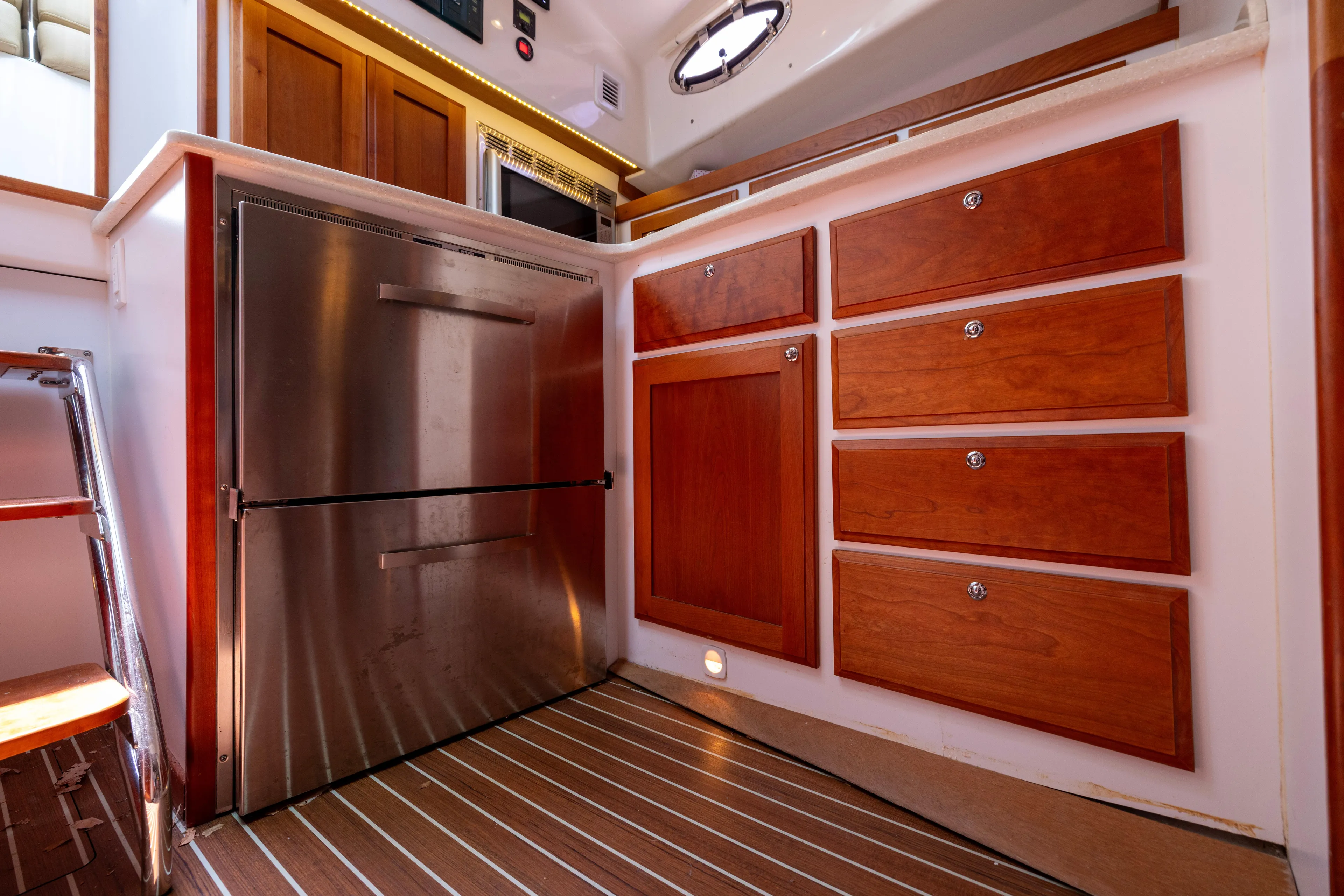 Waters Edge Yacht Photos Pics 2018 Back Cove Downeast 37 interior with stainless steel fridge and wooden cabinetry.