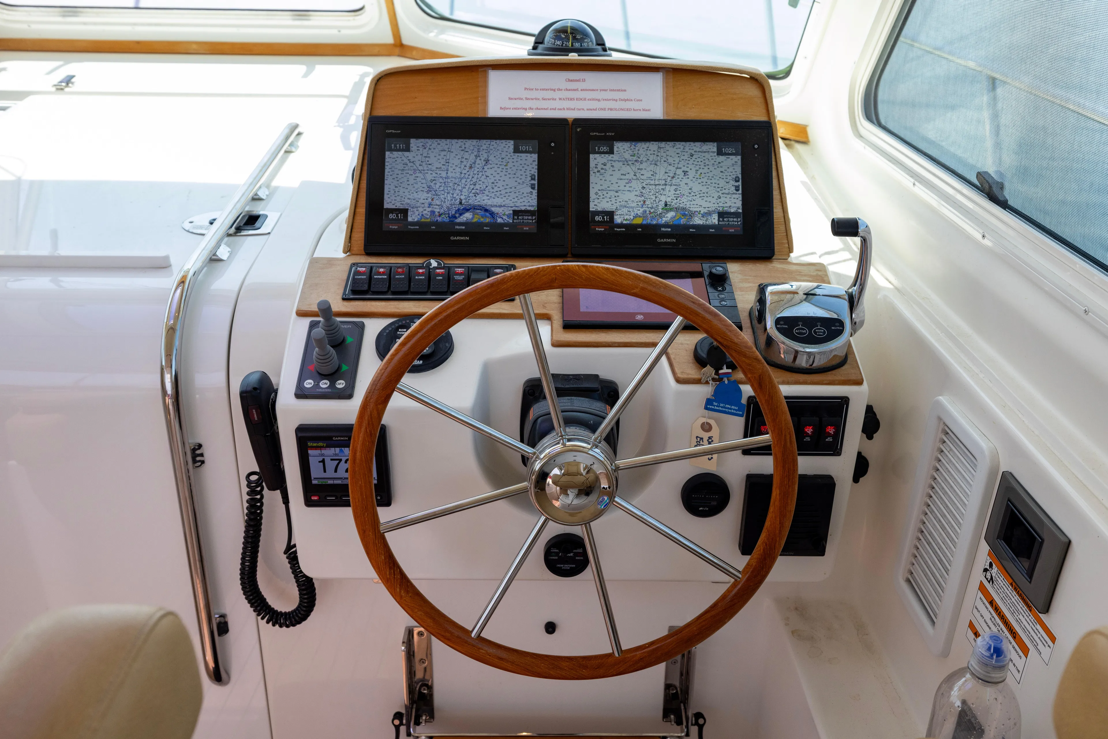 Waters Edge Yacht Photos Pics Helm of 2018 Back Cove Downeast 37 with navigation screens and wooden steering wheel.