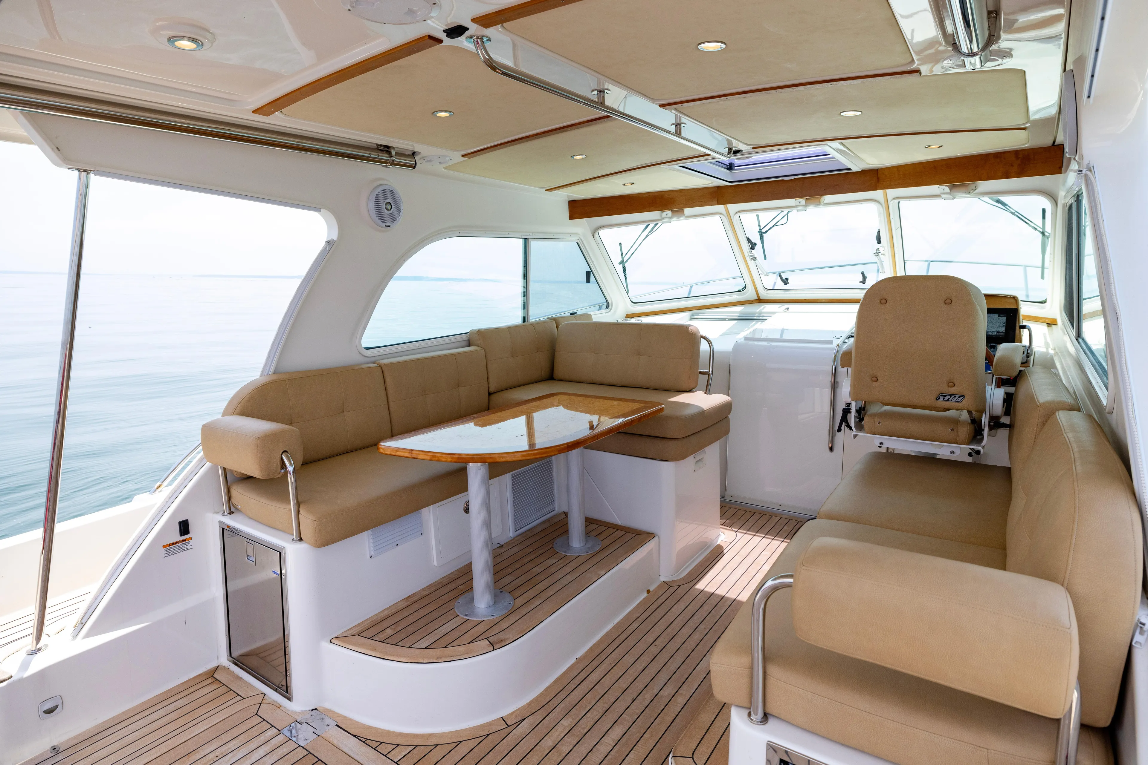 Waters Edge Yacht Photos Pics Luxurious interior of 2018 Back Cove Downeast 37 yacht with beige seating and wooden accents.