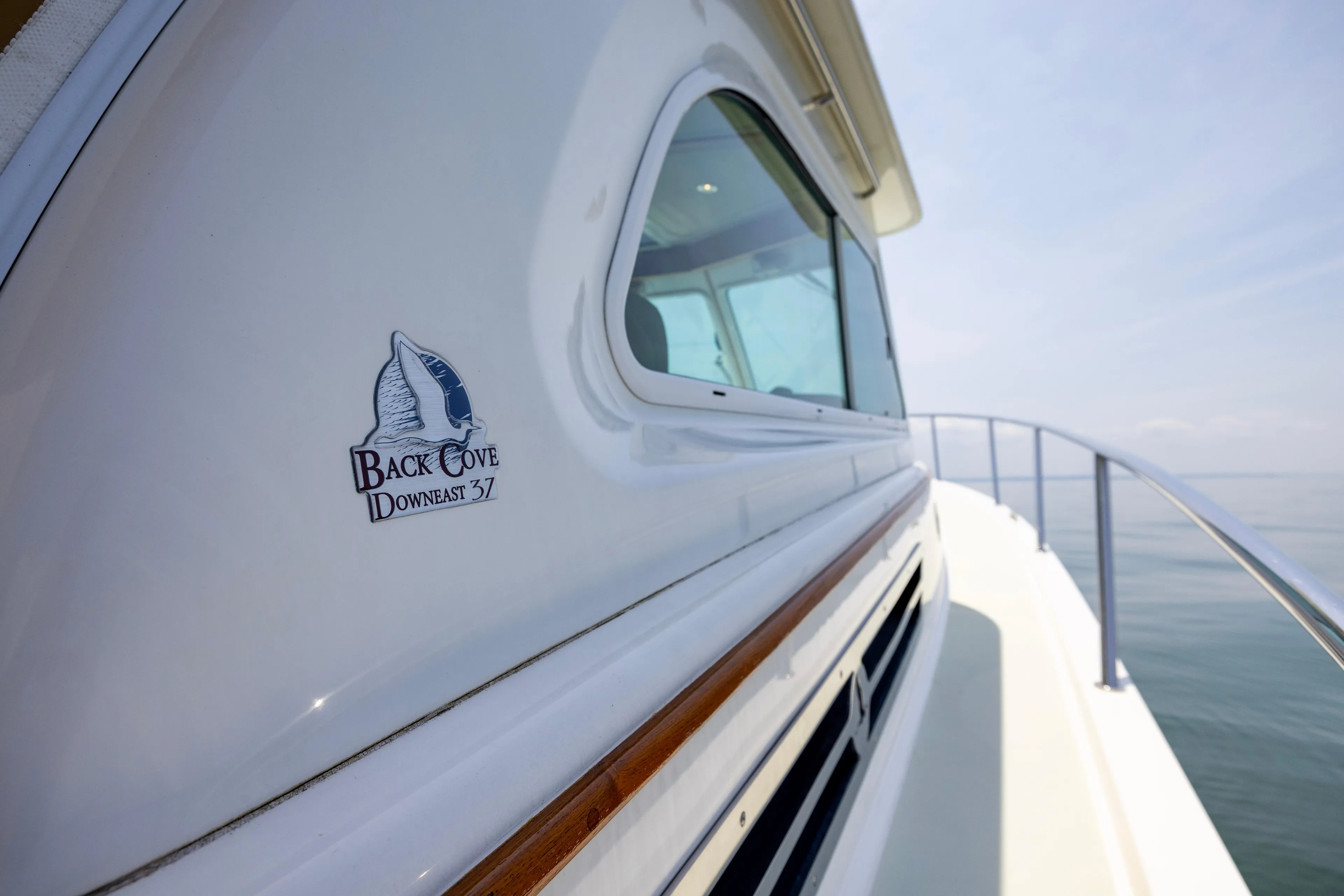 Waters Edge Yacht Photos Pics 2018 Back Cove Downeast 37 yacht, side view with logo, on calm water.