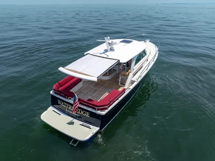 Waters Edge Yacht Photos Pics 2018 Back Cove Downeast 37 yacht cruising on open water, rear view.