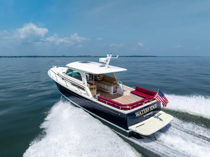 Waters Edge Yacht Photos Pics 2018 Back Cove Downeast 37 cruising on open water, displaying American flag.