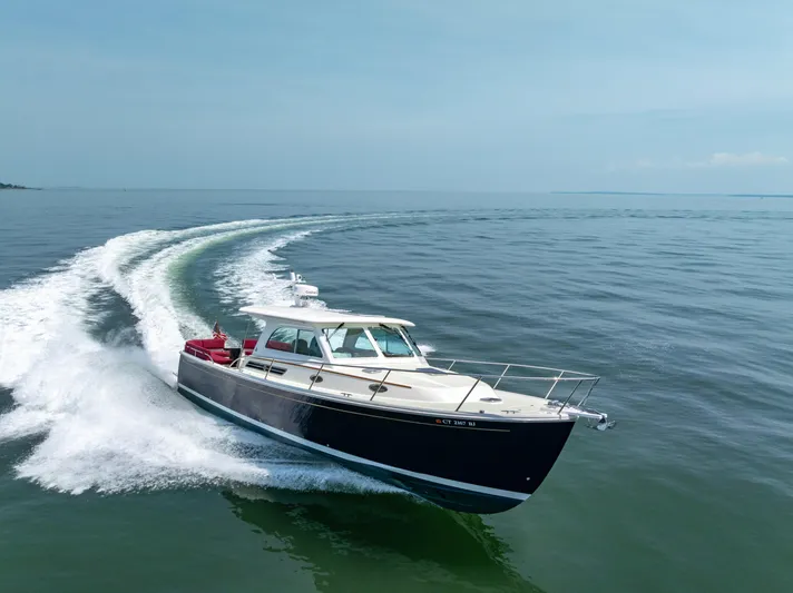 Waters Edge Yacht Photos Pics 2018 Back Cove Downeast 37 cruising on open water, creating a dynamic wake.