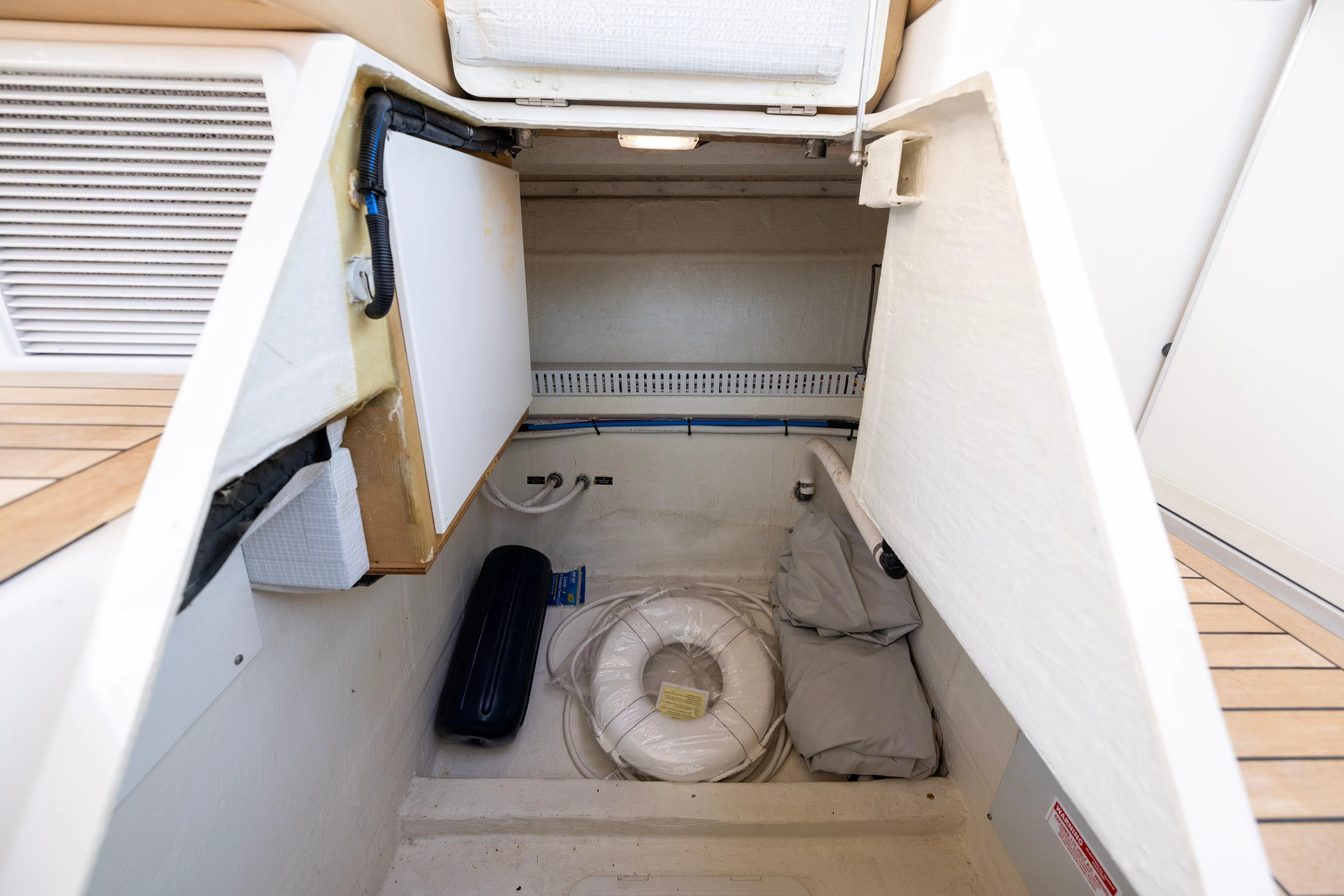 Waters Edge Yacht Photos Pics Storage compartment in 2018 Back Cove Downeast 37 boat, featuring life ring and equipment.