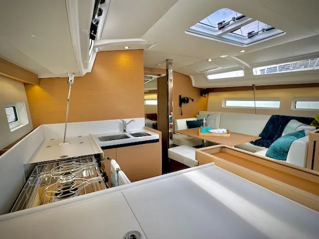 In Stock 440 #442 Yacht Photos Pics Modern interior of 2023 Jeanneau Sun Odyssey 440 yacht with kitchen and seating area.