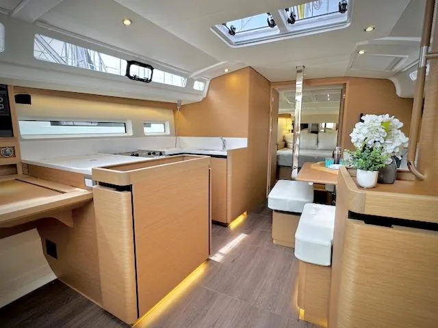 In Stock 440 #442 Yacht Photos Pics Interior of 2023 Jeanneau Sun Odyssey 440 yacht, featuring modern kitchen and dining area.
