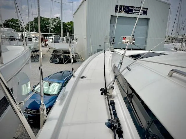 In Stock 440 #442 Yacht Photos Pics 2023 Jeanneau Sun Odyssey 440 sailboat docked near a marina building.