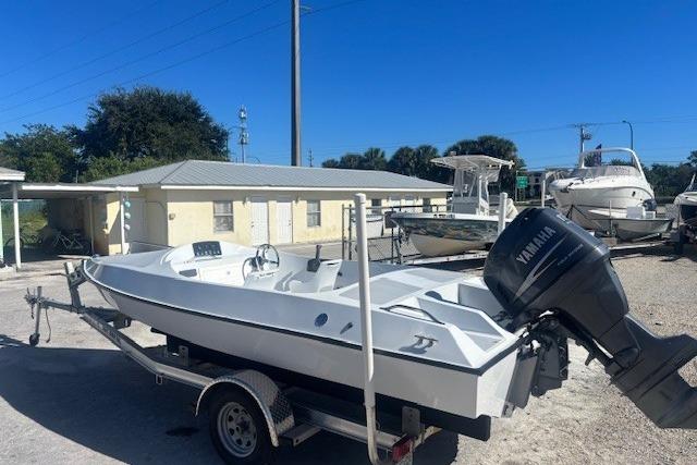 White JJM VS 1985 boat on trailer with Yamaha motor, parked outdoors.