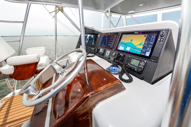 Fish Repellent Yacht Photos Pics Helm of 2000 Jarrett Bay 54 Convertible with navigation equipment and wooden steering wheel.