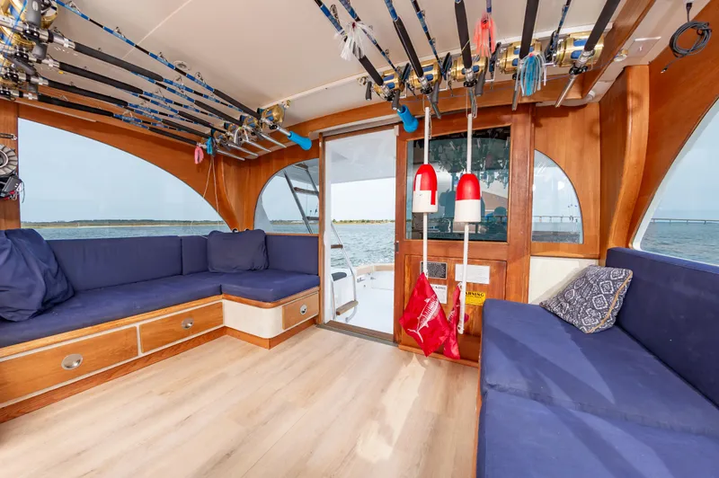 Fish Repellent Yacht Photos Pics Interior of 2000 Jarrett Bay 54 Convertible yacht with fishing rods and blue seating.