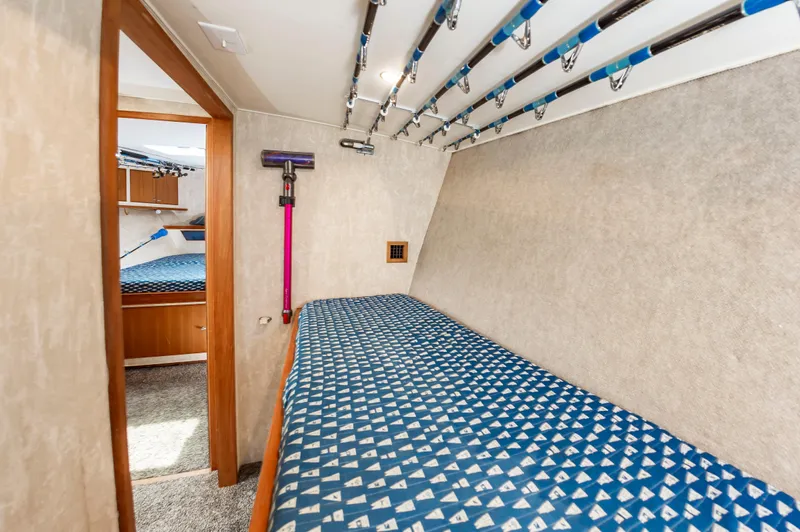 Fish Repellent Yacht Photos Pics Interior of 2000 Jarrett Bay 54 Convertible with fishing rods and patterned bedding.