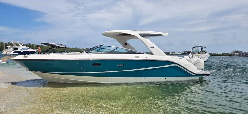  Yacht Photos Pics 2021 Sea Ray SLX 310 Outboard boat on clear water near a sandy shore.