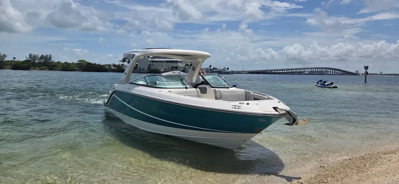  Yacht Photos Pics 2021 Sea Ray SLX 310 Outboard boat on a sunny beach with bridge in background.