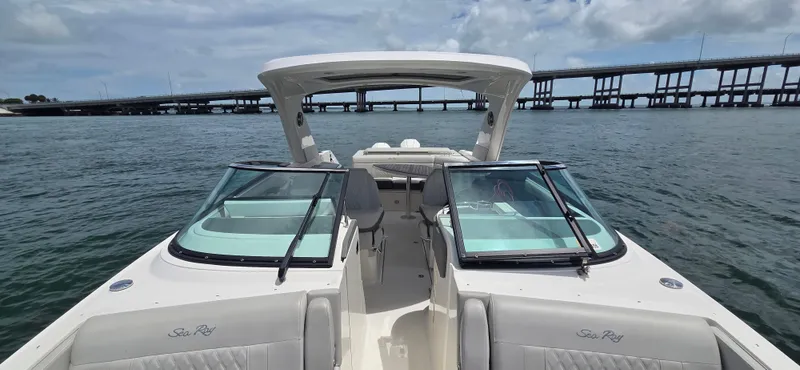  Yacht Photos Pics 2021 Sea Ray SLX 310 Outboard boat on water, bridge in background, clear sky.