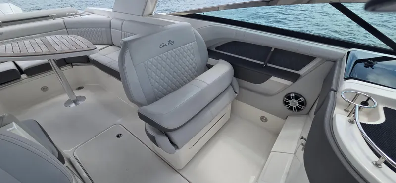  Yacht Photos Pics 2021 Sea Ray SLX 310 Outboard interior with luxurious seating and table, overlooking the water.