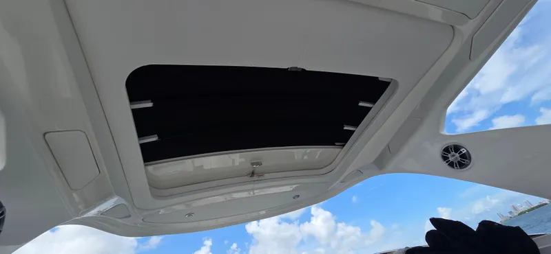  Yacht Photos Pics 2021 Sea Ray SLX 310 Outboard boat roof with open sunroof, blue sky background.